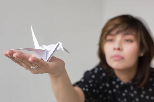 Fille tient une grue blanche origami . — Photo