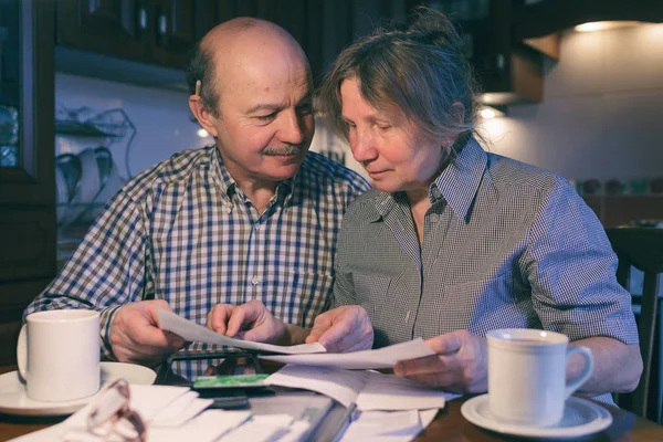 Een bejaarde echtpaar tellen van geld en een begroting. — Stockfoto