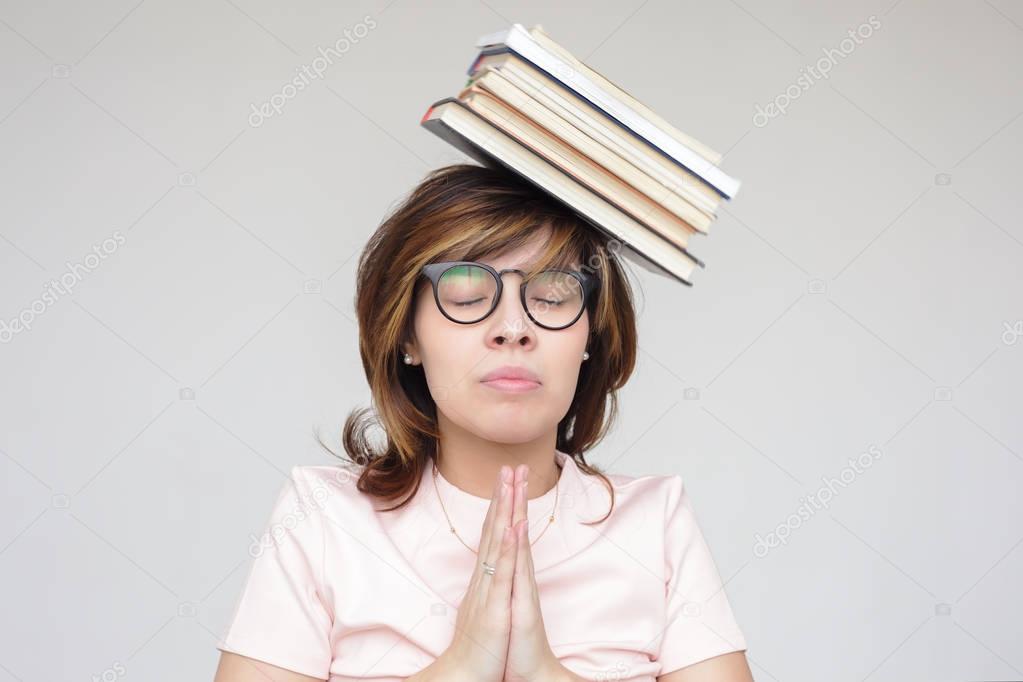 Girl meditates with a pile of books