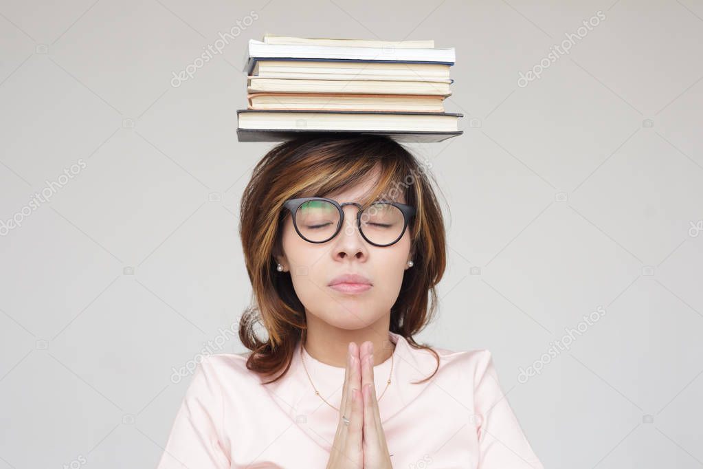Girl meditates with a pile of books 