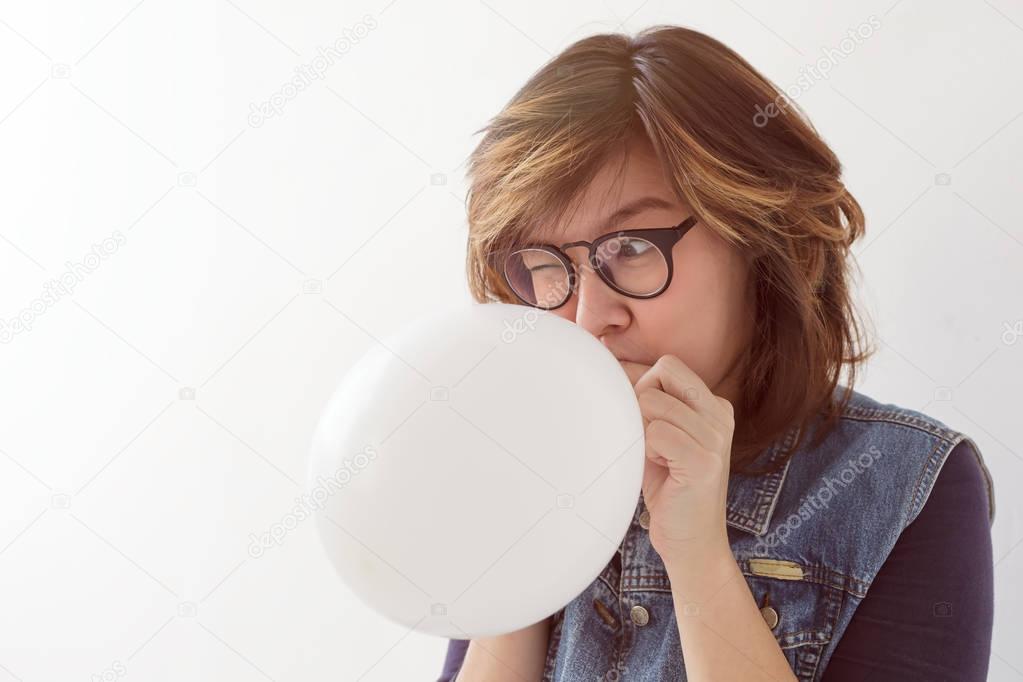 Girl inflates a balloon 