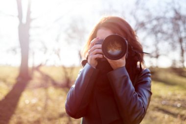 Kız bir kamera onun elinde tutan ve bir fotoğraf çeker 