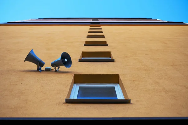 A parede da casa com janelas e alto-falantes . — Fotografia de Stock