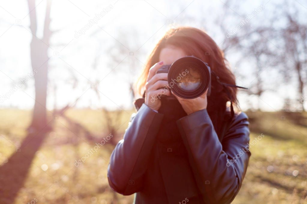 The girl holds a camera in her hands and takes a picture 