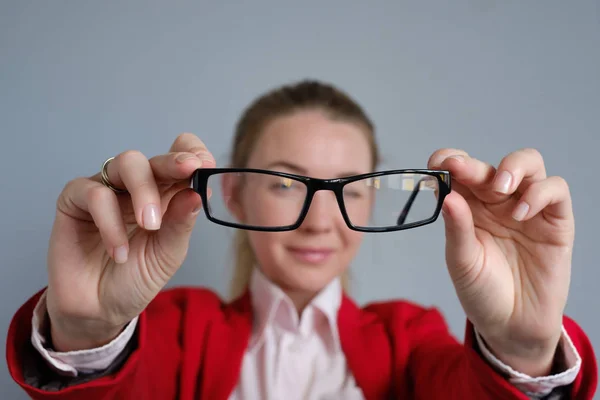 Femme tient des lunettes dans ses mains . — Photo