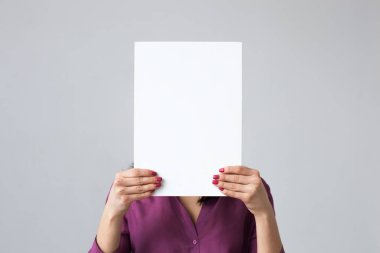 Kız beyaz bir sayfa onun elinde tutuyor