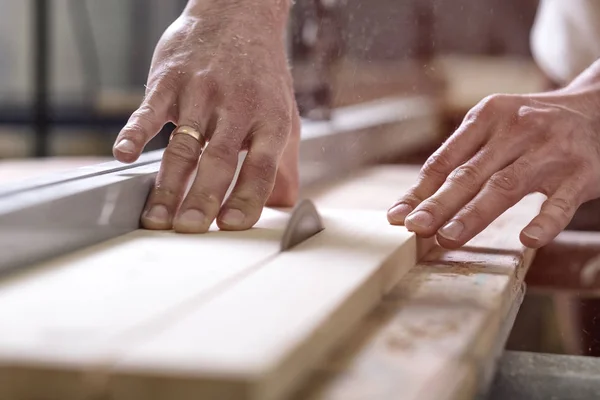 El carpintero sierra un trozo de madera en 2 partes con herramienta eléctrica — Foto de Stock