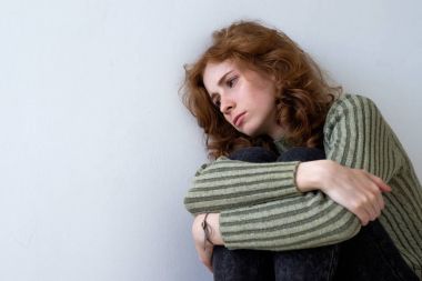 Güzel bir kızıl saçlı kız yorgun duvara yaslandı 