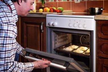 Apronda yaşlı bir adam evde turtalar hazırlar. Misafirperver bir h