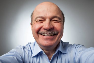 Yaşlı adam kulaktan kulağa komik hikayeleri kıkırdıyor gülüyor.