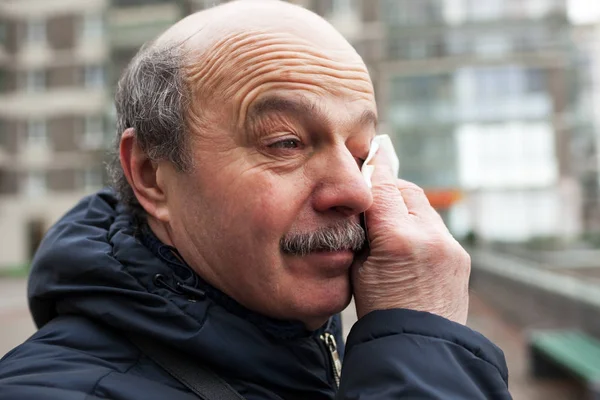 Un anciano con bigote y cabeza calva enjuga lágrimas — Foto de Stock