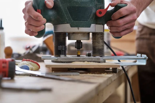 Der Tischler macht Löcher mit dem Bohrer in das Holzteil — Stockfoto