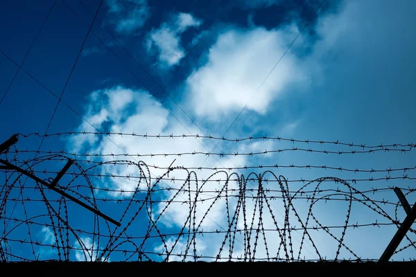 Bir hapishane veya gizli tesis çevresinde dikenli tel