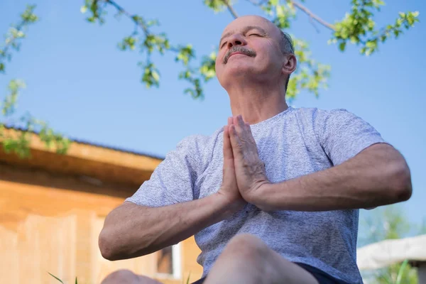 Yoga bij park. Senior man met snor met namaste zitten. Concept van rust en meditatie. — Stockfoto