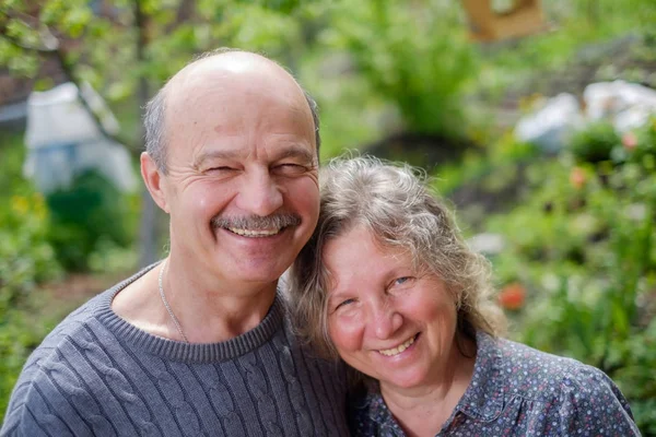 Liefdevolle ouder paar achteraan in de tuin tuin in zonnige dag — Stockfoto