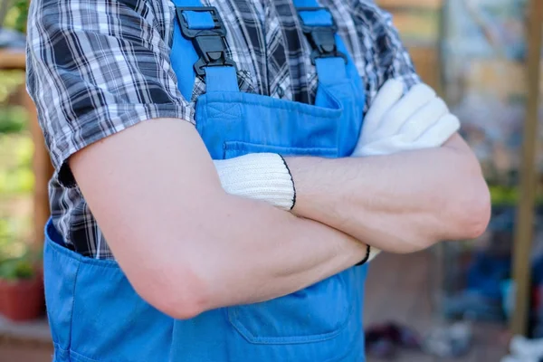 Caucasian young gardener in overalls with crossed hands — Stock Photo, Image