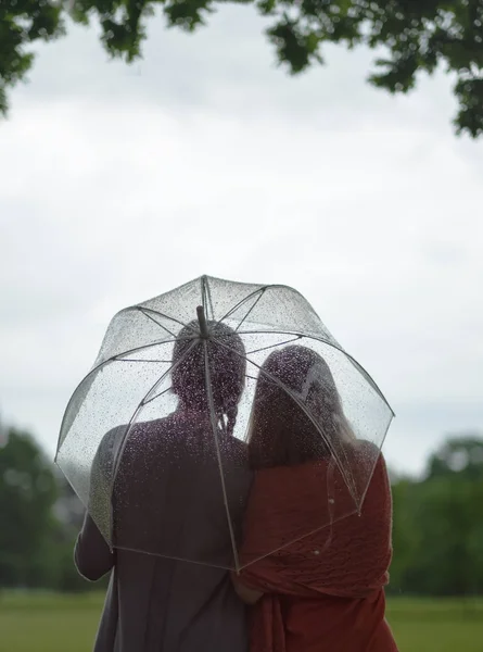 Δύο γυναίκες με τα πόδια πάρκο στη βροχή και να μιλήσουμε. Ανακοίνωση της φιλίας και ανθρώπους. Των βροχών — Φωτογραφία Αρχείου