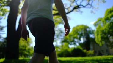 Bahçede yürüyüş ve güneşli yaz gününde bir parkta yeşil çimenlerin üzerinde oturarak mutlu düşünceli hayalperest biri.