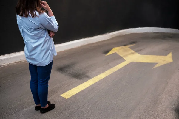 Молода жінка стоїть перед двома дорогами — стокове фото