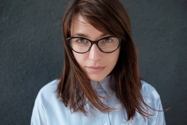 Closeup portrait of young attractive woman with glasses on a dark background. — Stock Photo, Image