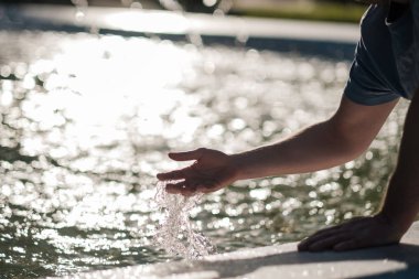 Su sıçrama, arkadan aydınlatmalı akşam güneşi tarafından elle.