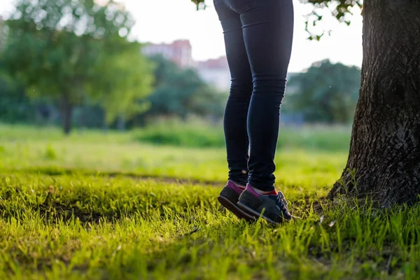 La chica se levanta de puntillas, tratando de trepar a un árbol . —  Fotos de Stock