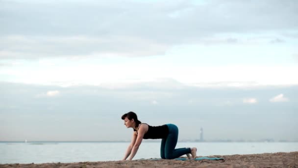 Kaukasische dünne hübsche Frau Yoga am Strand — Stockvideo