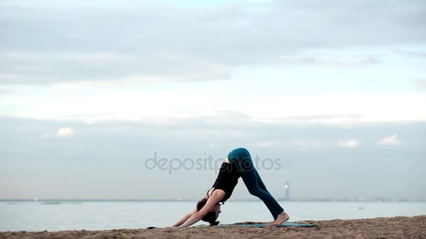 Kaukasische dünne hübsche Frau Yoga am Strand — Stockvideo
