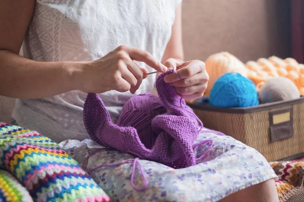 Caucasian woman knits woolen clothes. Holding knitting needles at hands — Stock Photo, Image