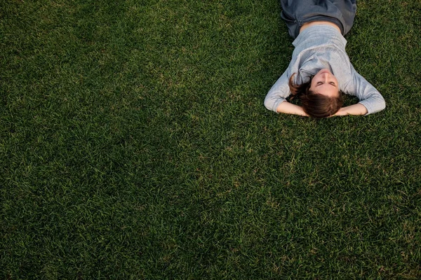 Hermosa mujer europea joven se acuesta en la hierba y descansa — Foto de Stock