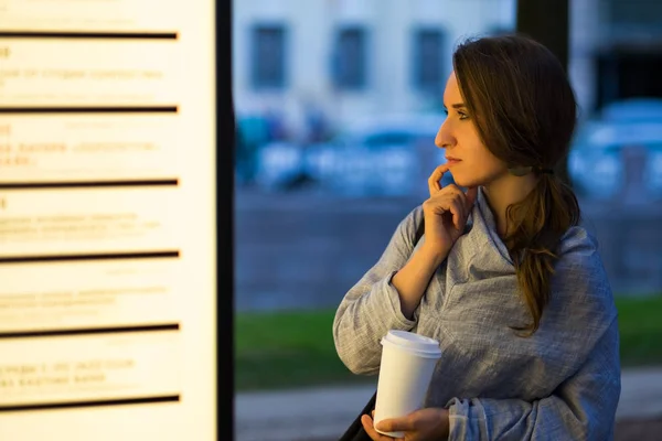 Krásná žena s úroky při pohledu na prázdné billboard rozhodování, kam jít — Stock fotografie