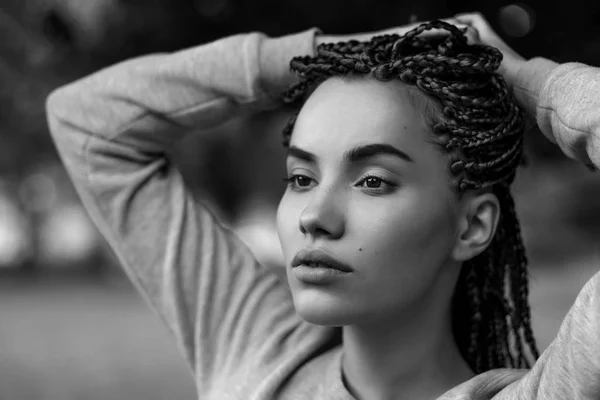 A black-and-white portrait of a beautiful girl with plaited braids. — Stock Photo, Image