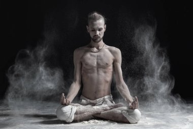 Cross-legged yoga lotus poz, Padmasana avuç içi mudra ile meditasyon oturan sportif sakin genç adam