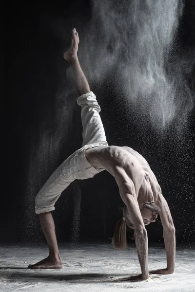 Zijaanzicht van caucaisanl jonge man aan het werk buiten, yoga doen of oefening pilates. Brug pose, Urdhva Dhanurasana. — Stockfoto