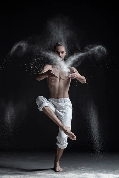 Portret van Kaukasische jonge man dragen witte sport broek doen yoga of pilates oefening. — Stockfoto