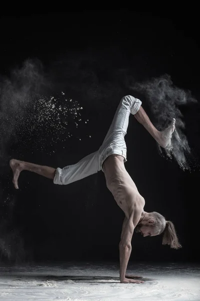 Flexibele yoga man hand evenwicht asana vrischikasana doen. — Stockfoto