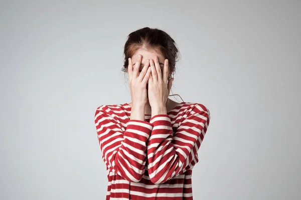 Pretty caucasian girl covers her face with her hands — Stock Photo, Image