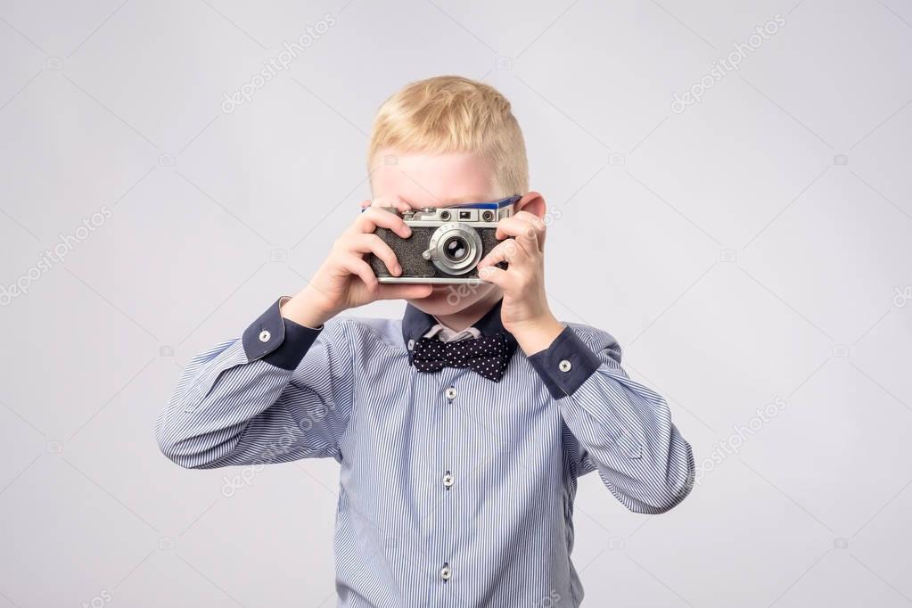 Cheerful smiling child boy holding a instant camera