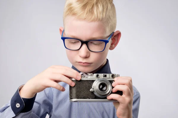 Alegre niño sonriente sosteniendo una cámara instantánea —  Fotos de Stock