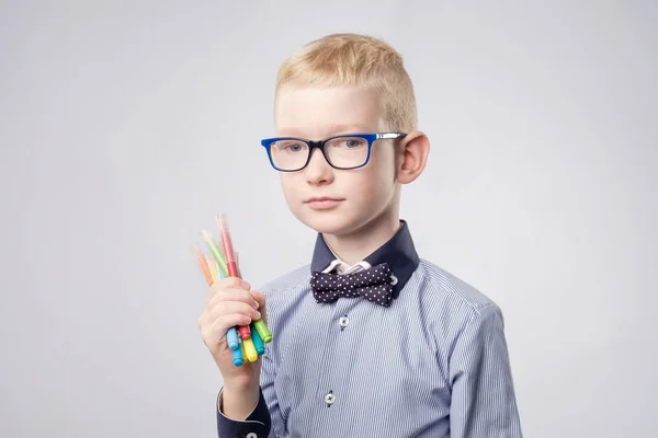 Hvid dreng med blond hår, der holder blyanter i hænder og kigger op - Stock-foto