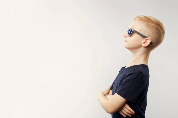 Porträt eines kaukasischen Jungen mit Sonnenbrille, der isoliert auf weißem Hintergrund nach oben blickt. — Stockfoto