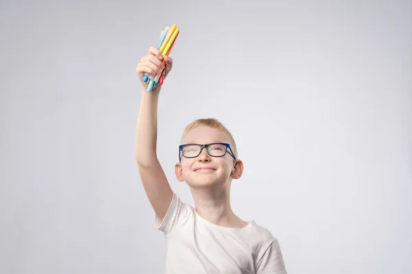 Caucásico chico con pelo rubio sosteniendo lápices en las manos y mirando hacia arriba —  Fotos de Stock