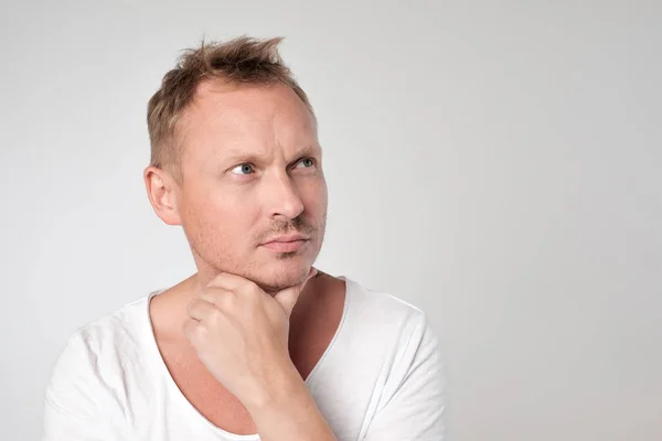 Portrait of handsome caucasian man looking with doubt up. — Stock Photo, Image