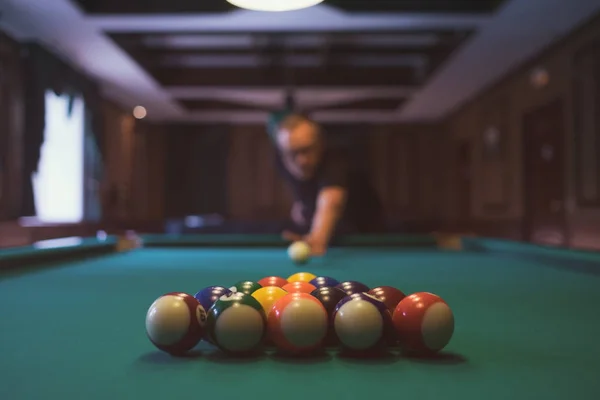 Jovem a jogar bilhar dentro de casa. Passar tempo livre em jogos de azar — Fotografia de Stock