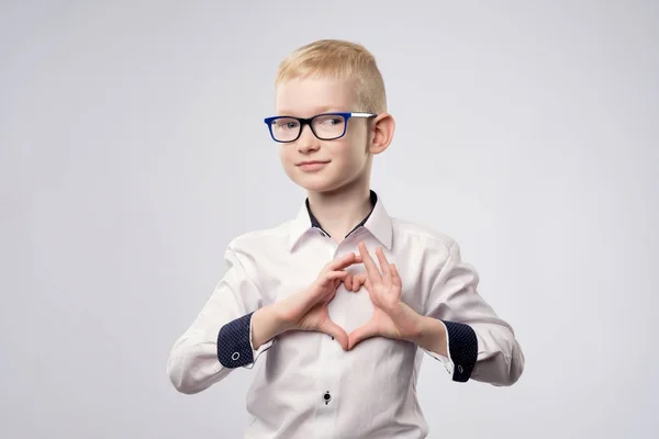 Porträt eines glücklichen Jungen mit einer Herzform isoliert auf weißem Hintergrund — Stockfoto