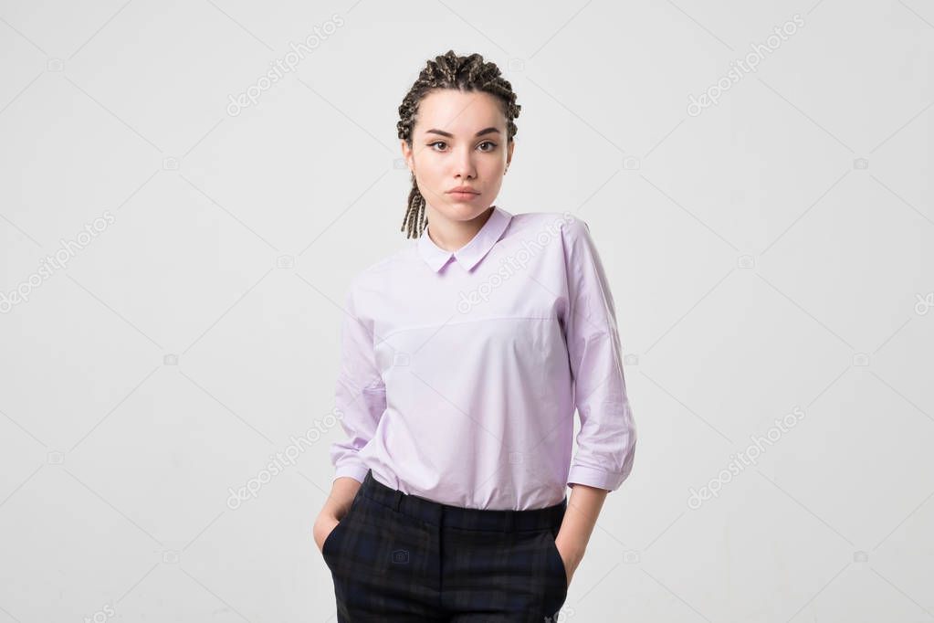 confident caucasian woman standing with arms in pockets isolated over white background