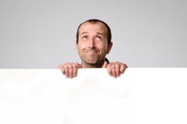 İspanyol adam boş işareti bir stüdyo beyaz arka planda tutar..