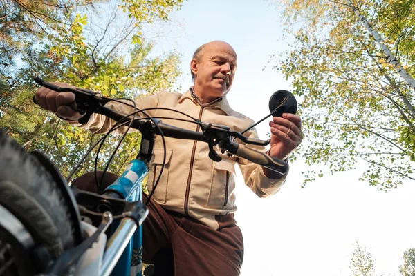 Starszy człowiek na cykl jazdy w okolicy — Zdjęcie stockowe