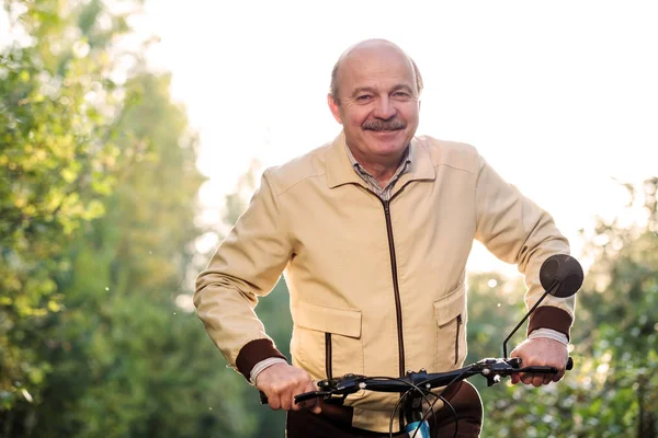 Senior homem em passeio de bicicleta no campo — Fotografia de Stock