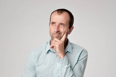 Yüzündeki şüpheci duygu ile seyir siyah tişörtlü beyaz adam.